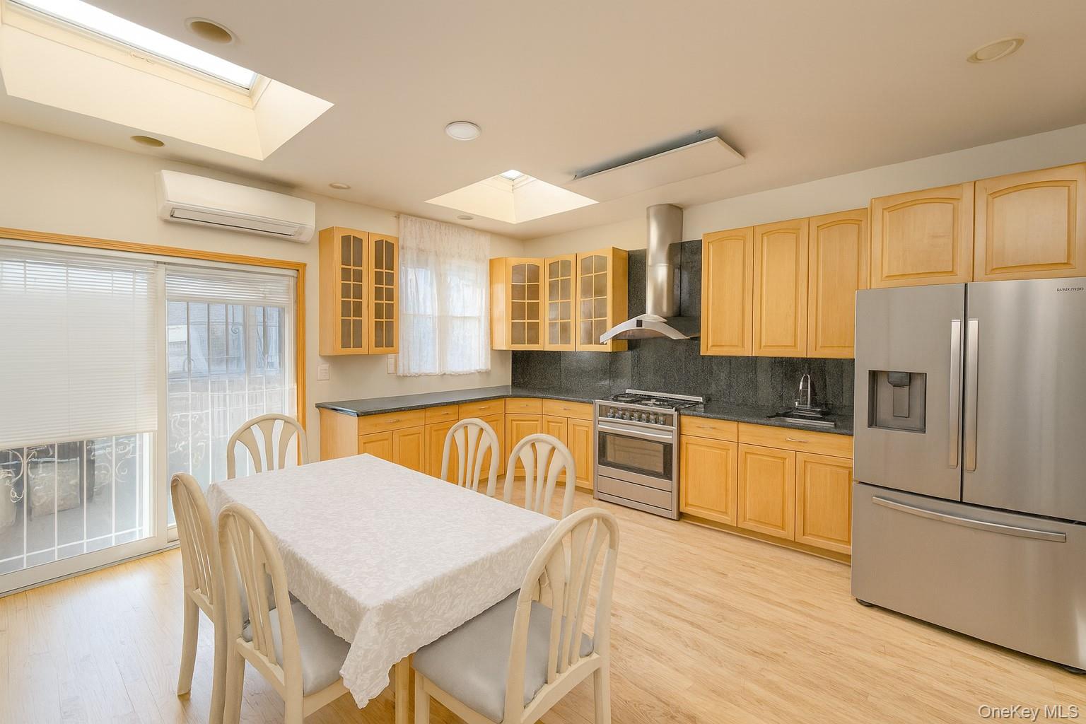 144-24 Jewel Avenue Queens, NY 11367 - Photo 8 of 12 a kitchen with stainless steel appliances granite countertop a refrigerator a sink a stove and white cabinets with wooden floor