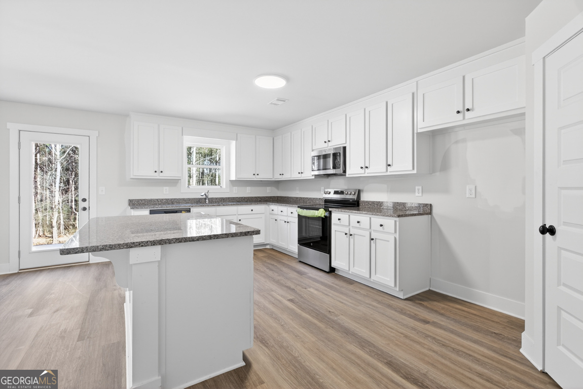 538 Oil Mill Road, Unit 8 Martin, GA 30557 - Photo 20 of 50 a kitchen with stainless steel appliances granite countertop a stove top oven a sink dishwasher and a refrigerator with wooden floor