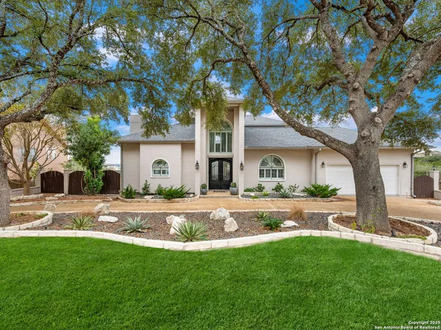 a front view of a house with a garden and trees