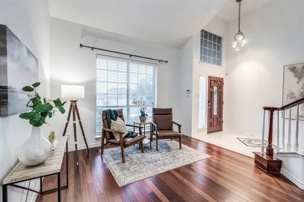 a living room with furniture a wooden floor and a potted plant