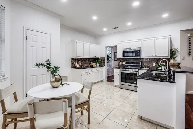 a kitchen with stainless steel appliances a stove a sink a microwave a refrigerator and cabinets