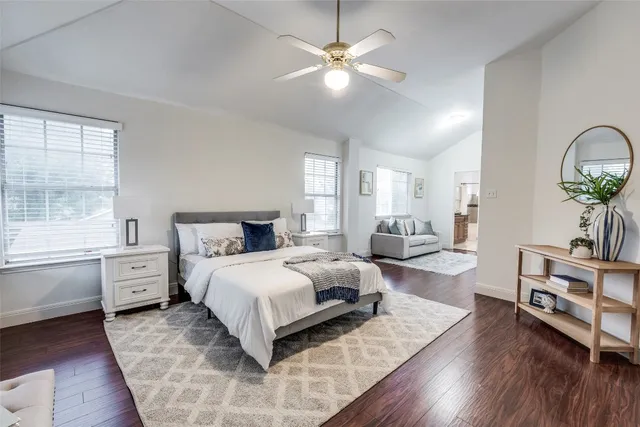 a bedroom with a large bed and wooden floor