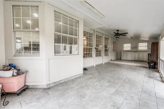 a view of an empty room with a window and chandelier