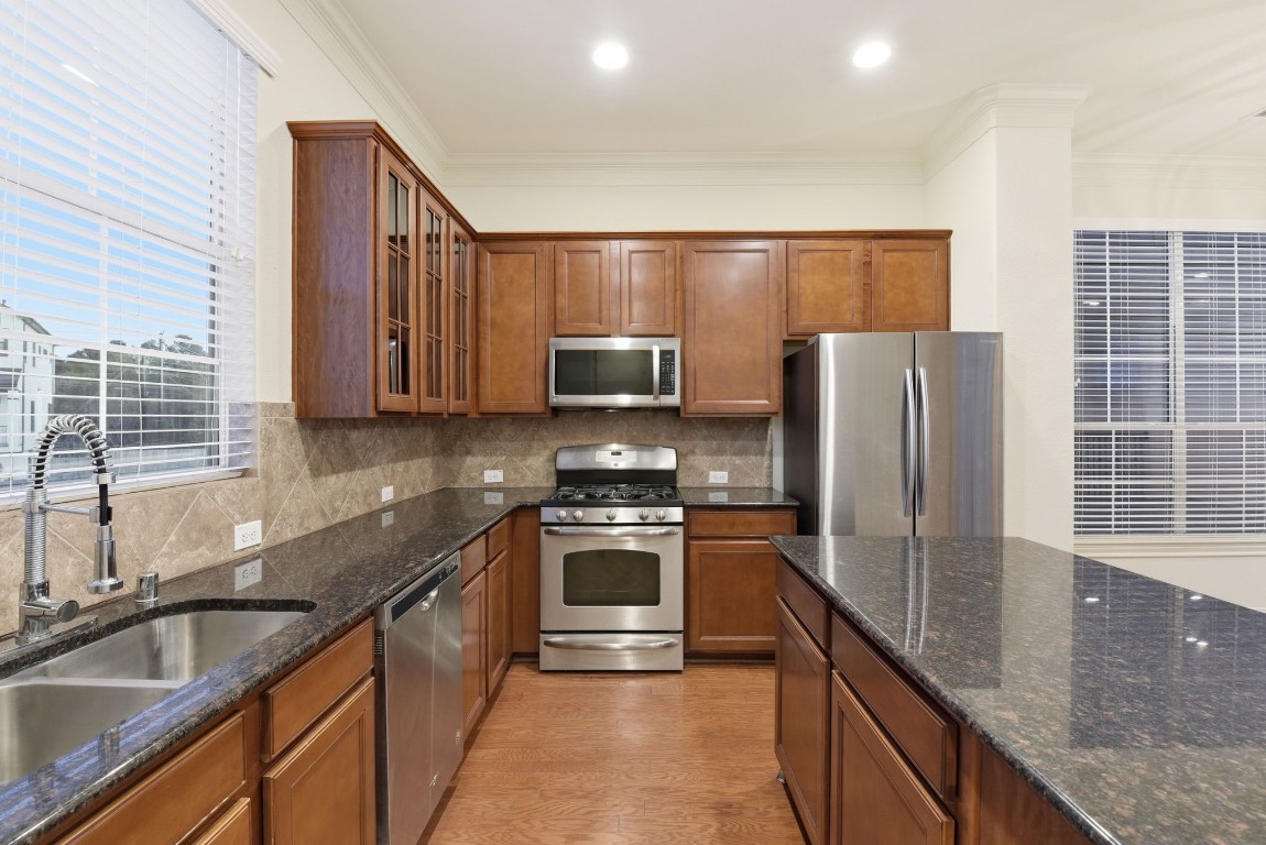 3209 Clearview Circle Houston, TX 77025 - Photo 23 of 40 a kitchen with kitchen island granite countertop a sink stainless steel appliances and cabinets