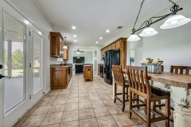 a kitchen with stainless steel appliances kitchen island granite countertop a refrigerator a stove a sink dishwasher and a dining table with wooden floor