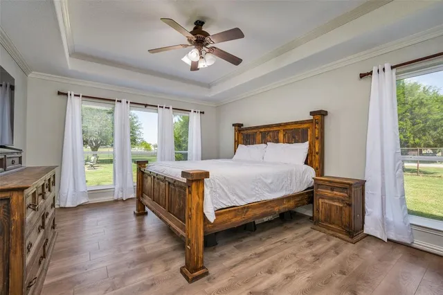 a bed sitting in a spacious bedroom next to a window