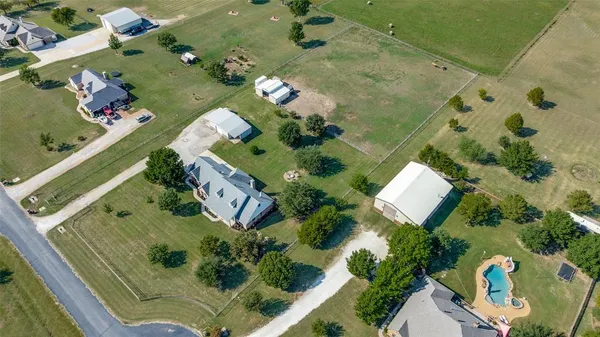 an aerial view of a residential houses with outdoor space and street view