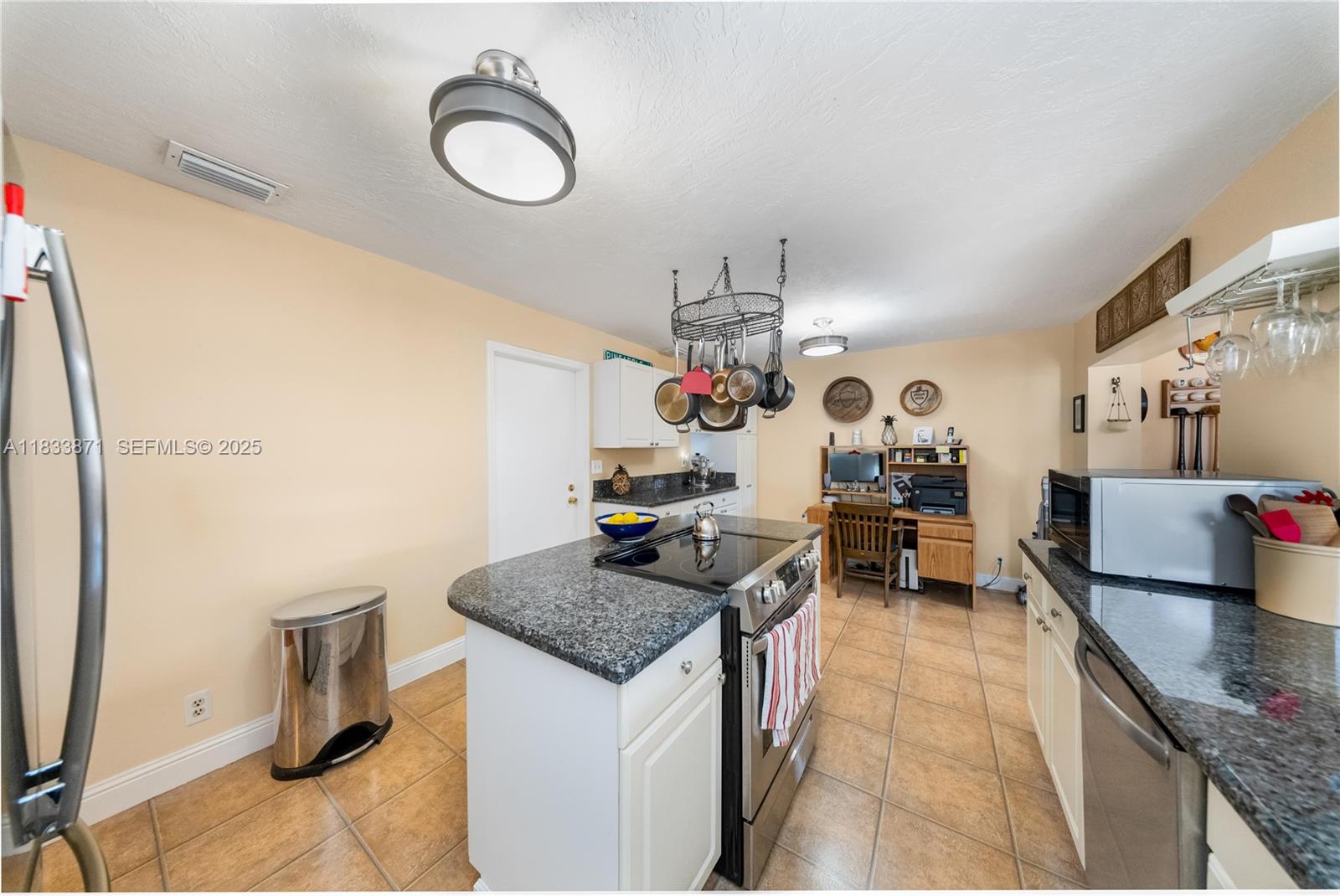 11193 Southwest 113th Terrace Miami, FL 33176 - Photo 12 of 43 a kitchen that has a stove and a table in it