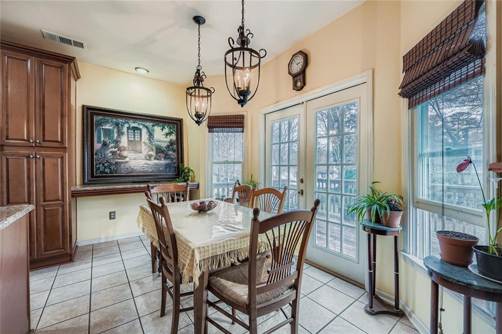 932 Huntsman Trace Lawrenceville, GA 30045 - Photo 11 of 30 a dining room with furniture a flat screen tv and a chandelier