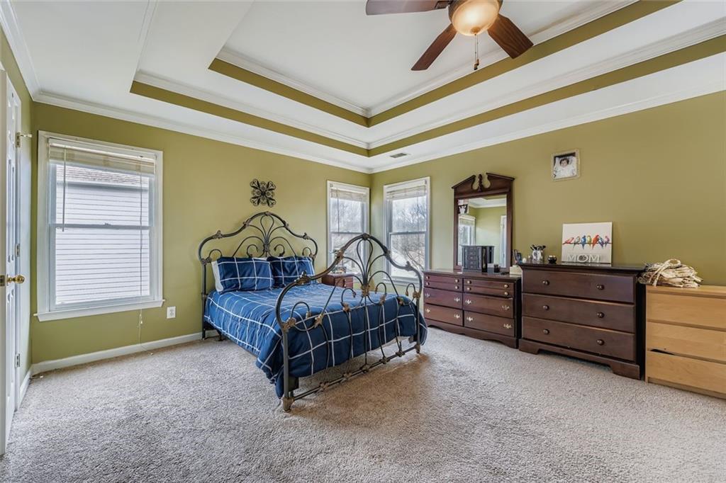 932 Huntsman Trace Lawrenceville, GA 30045 - Photo 13 of 30 a bedroom with a bed and a dresser next to a window