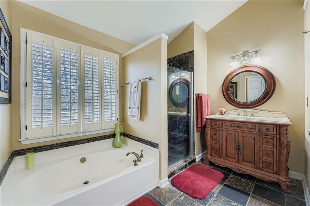 932 Huntsman Trace Lawrenceville, GA 30045 - Photo 15 of 30 a bathroom with a tub sink and mirror