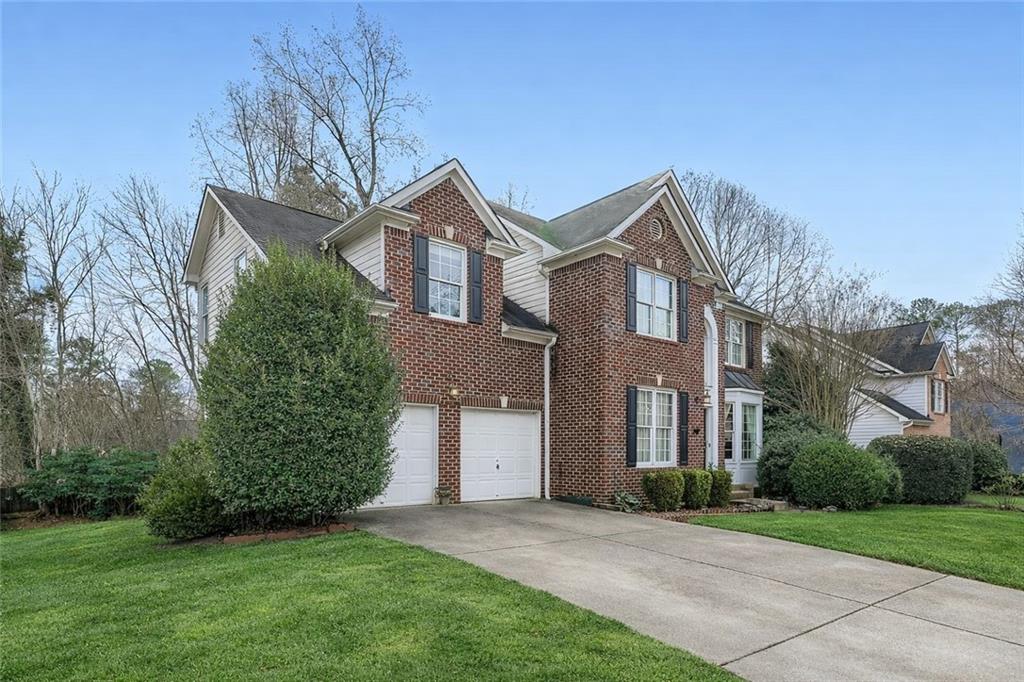932 Huntsman Trace Lawrenceville, GA 30045 - Photo 2 of 30 a front view of a house with a yard and trees