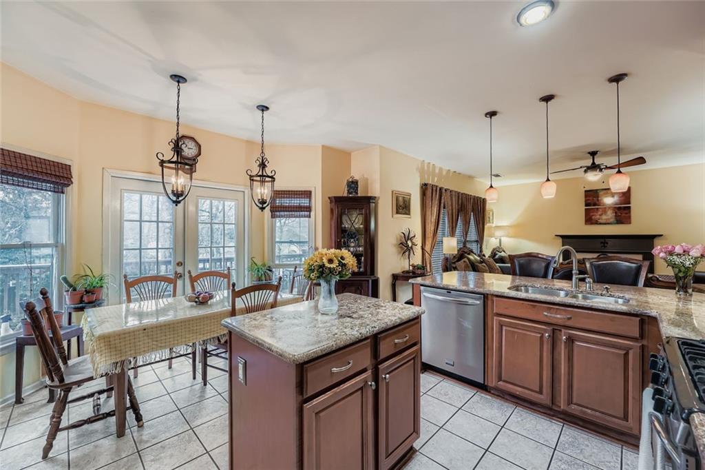 932 Huntsman Trace Lawrenceville, GA 30045 - Photo 9 of 30 a kitchen with a stove a sink and chairs