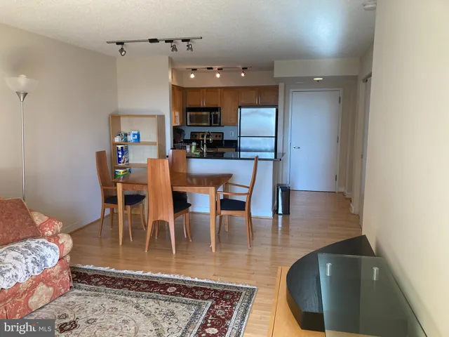 a kitchen with stainless steel appliances granite countertop a refrigerator a stove and a sink with wooden floor