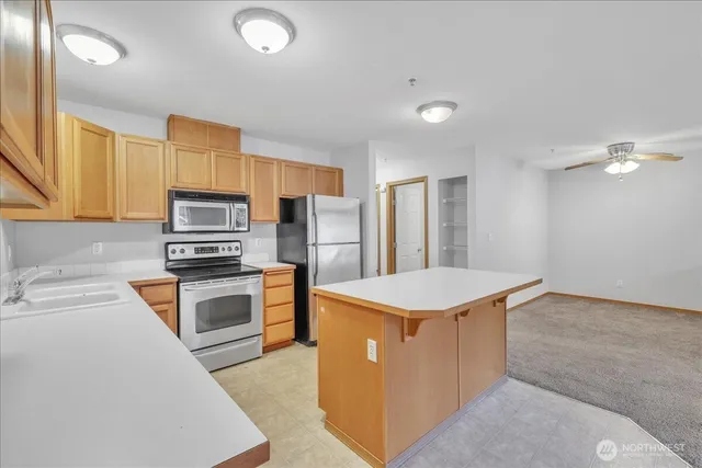 a kitchen with stainless steel appliances a refrigerator sink stove and oven