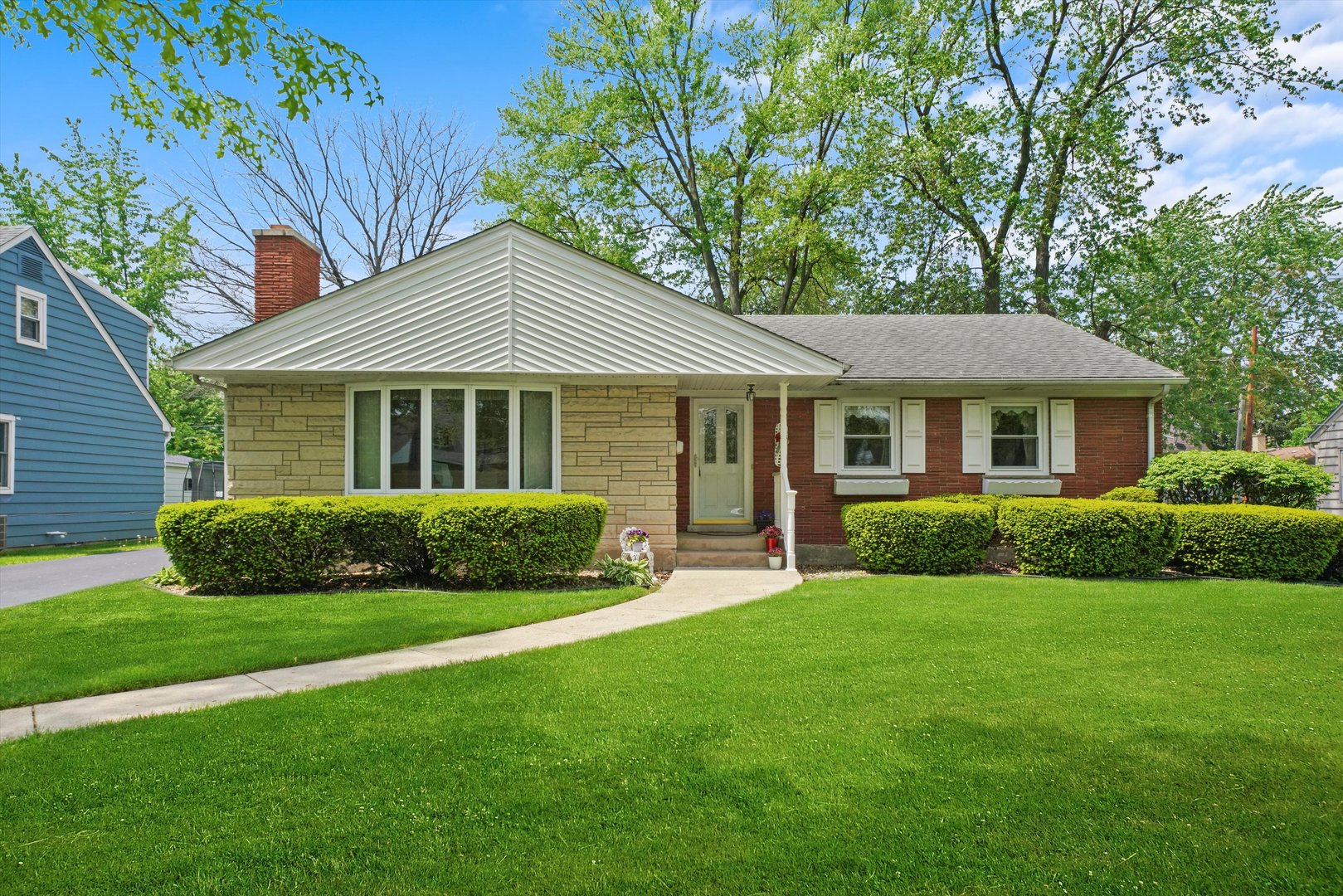 a front view of a house with a yard and green space