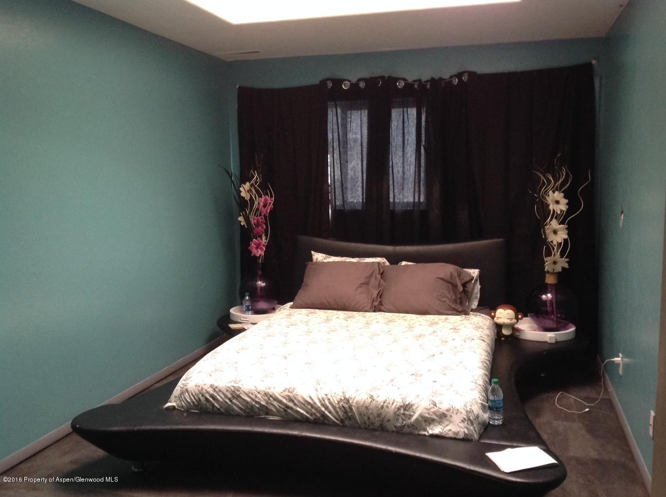 125 Daniel Avenue Rifle, CO 81650 - Photo 12 of 12 a bed sitting in a bedroom next to a lamp