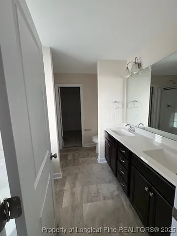 a spacious bathroom with a double vanity sink a and a mirror
