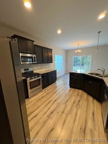 a kitchen with stainless steel appliances a sink a stove top oven a counter space and cabinets