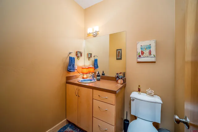 a bathroom with a sink mirror vanity and toilet