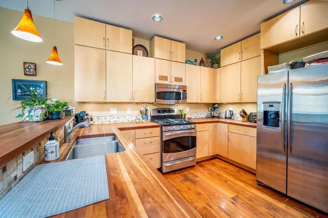 a kitchen with stainless steel appliances granite countertop a stove a sink and a refrigerator