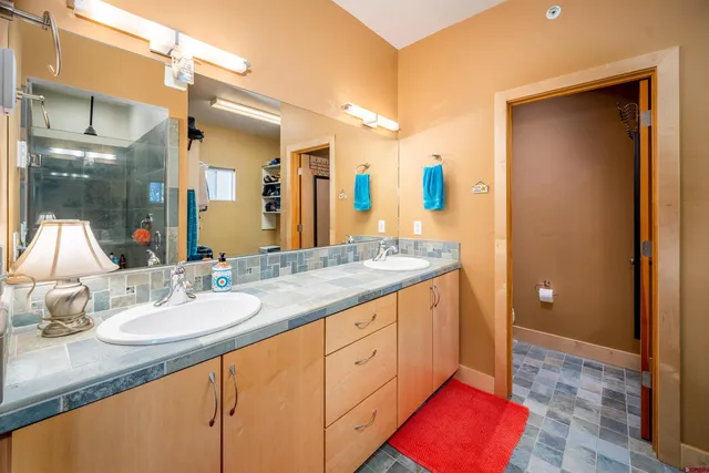 a spacious bathroom with a granite countertop sink and a mirror