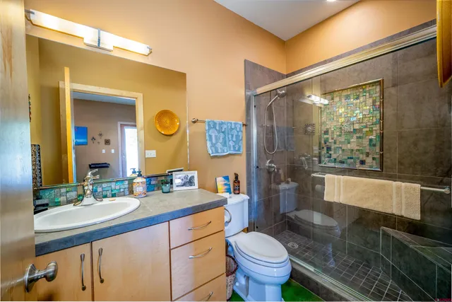 a bathroom with a granite countertop sink toilet and a mirror