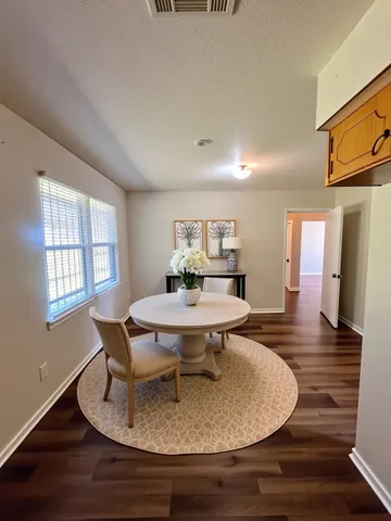a dining room with furniture and wooden floor