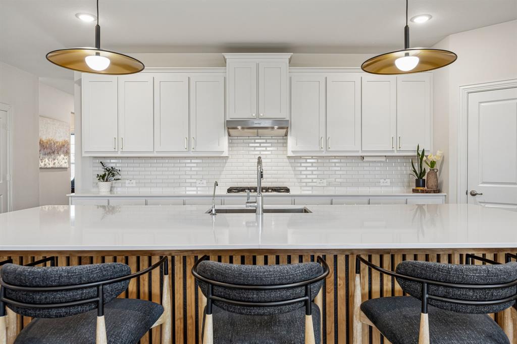 425 Breeds Hl Road Little Elm, TX 75068 - Photo 6 of 38 a kitchen with kitchen island a white cabinets and a chairs