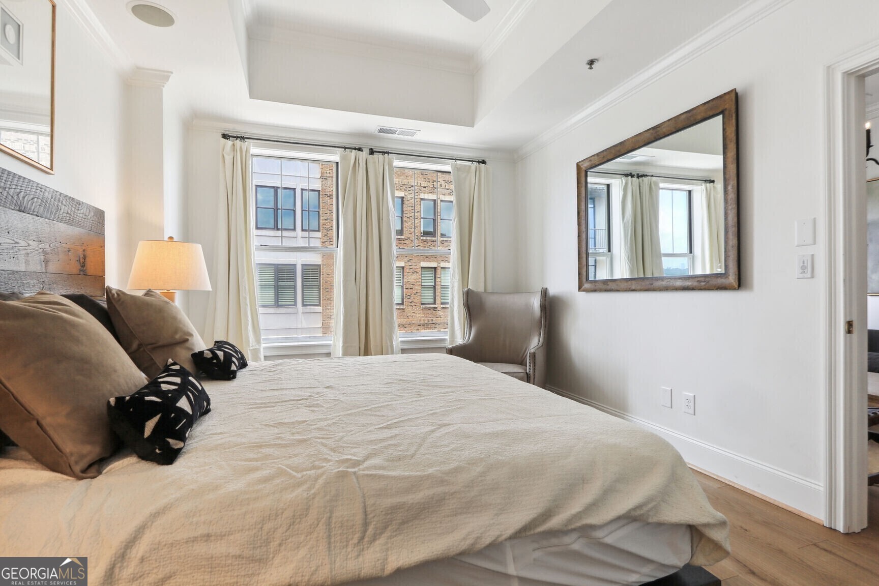 2255 Peachtree Road Northeast, Unit 825 Atlanta, GA 30305 - Photo 11 of 15 a bedroom with a bed window and walk in closet with wooden floor
