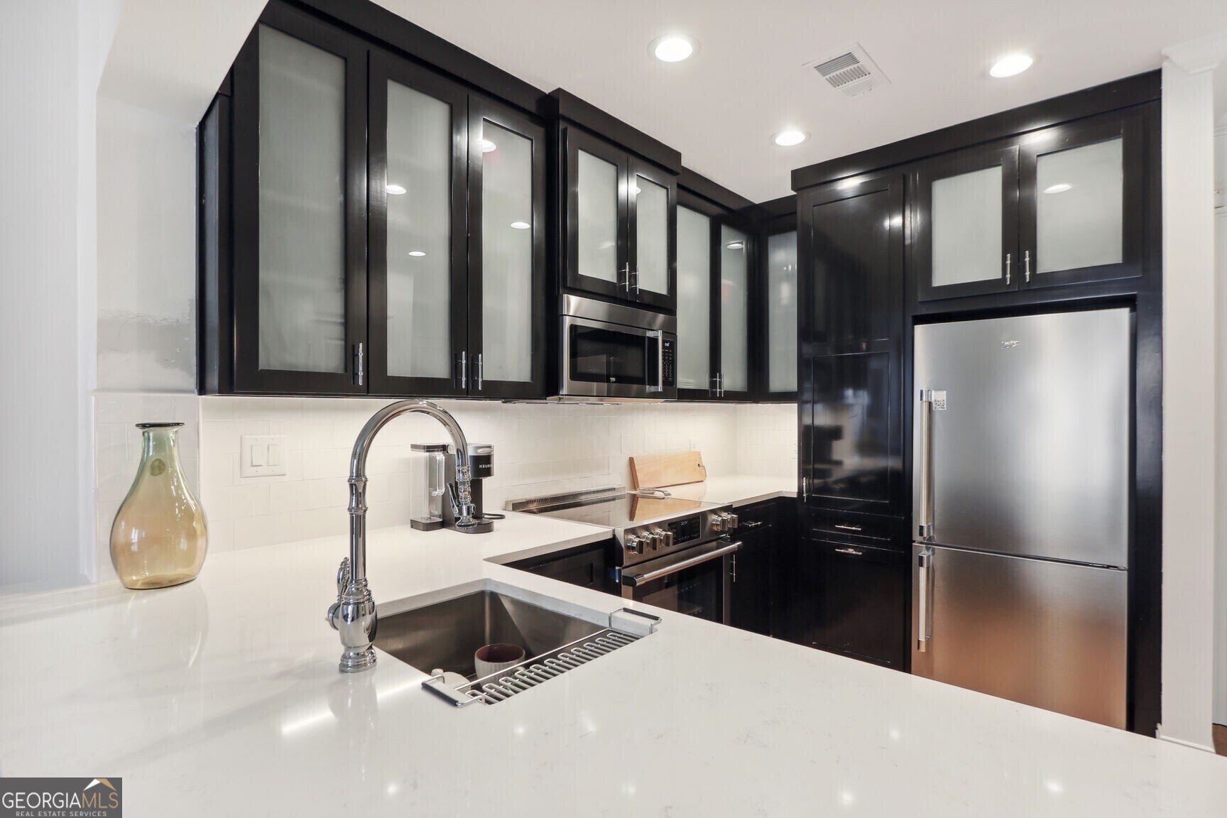 2255 Peachtree Road Northeast, Unit 825 Atlanta, GA 30305 - Photo 8 of 15 a kitchen with granite countertop a refrigerator and a sink