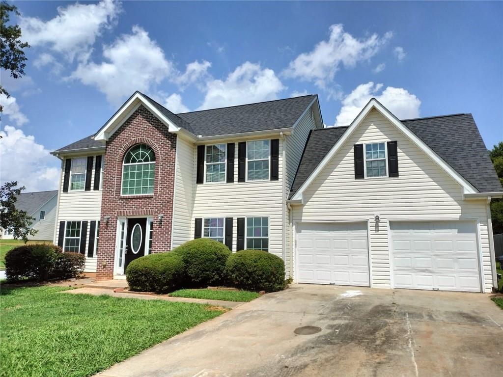 a front view of a house with a garden and yard