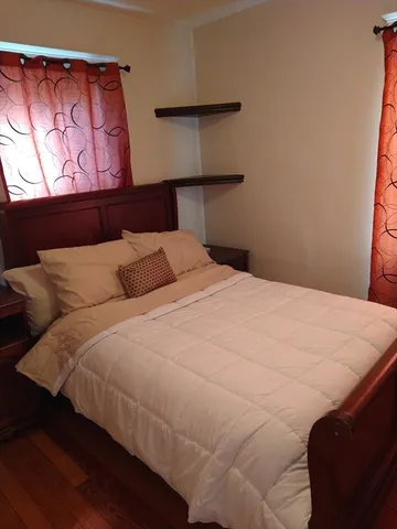 a bedroom with a bed and a night stand