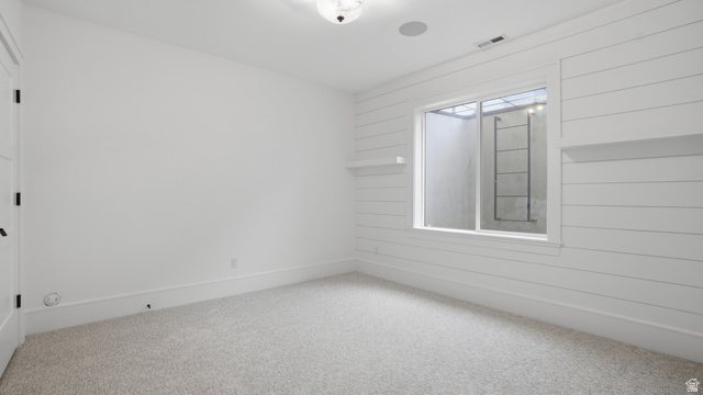 1682 North 1950 W Street, Unit 9 Provo, UT 84604 - Photo 50 of 84 Room featuring shiplap accent wall with integrated shelving, window with exterior ladder, recessed ceiling speaker, and light-toned carpet flooring