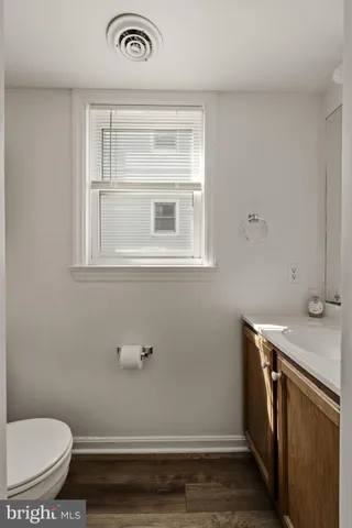 a bathroom with a sink a toilet and a window