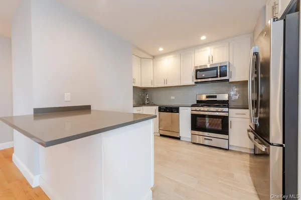 a kitchen with stainless steel appliances a stove microwave and refrigerator