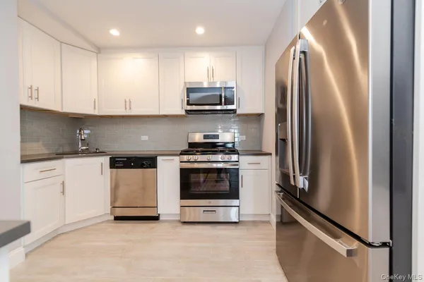 a kitchen with stainless steel appliances granite countertop a refrigerator sink and stove