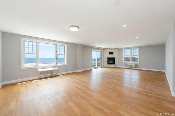 a view of empty room with wooden floor and fireplace