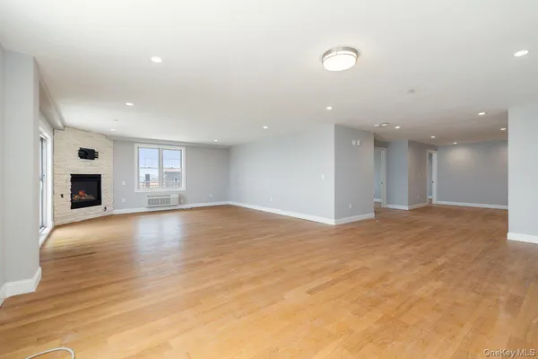 a view of empty room with wooden floor and fireplace