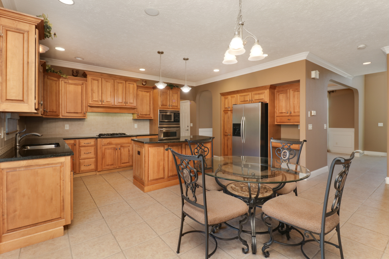 4012 Rockledge Road Bloomington, IL 61705 - Photo 18 of 63 a kitchen with kitchen island granite countertop wooden floors and white cabinets