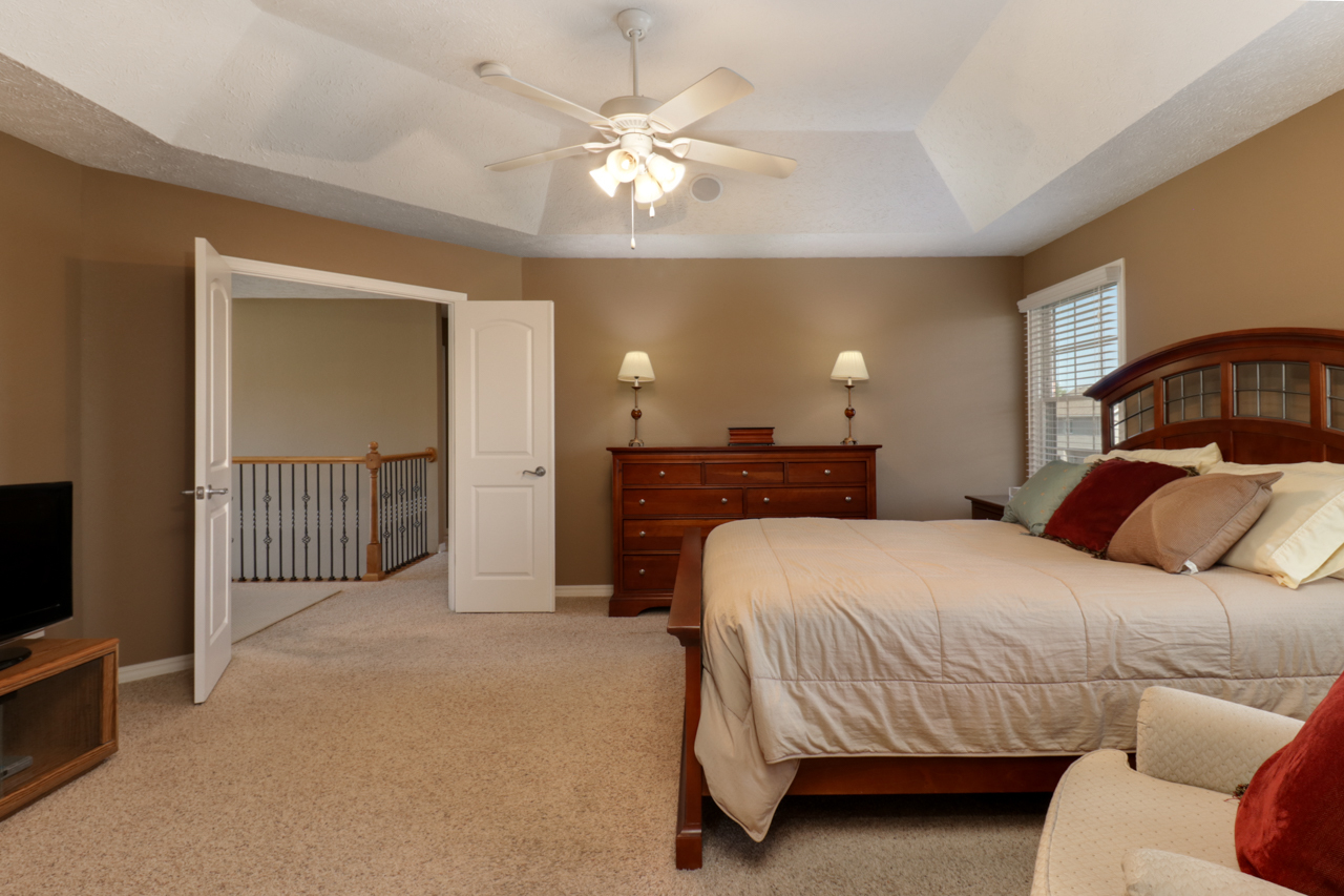 4012 Rockledge Road Bloomington, IL 61705 - Photo 31 of 63 a bedroom with a large bed a chandelier and dresser