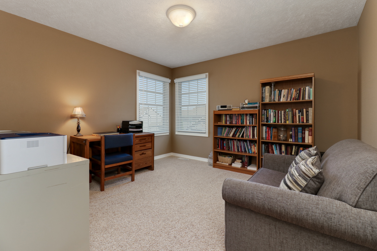 4012 Rockledge Road Bloomington, IL 61705 - Photo 38 of 63 a living room with furniture and a bookshelf