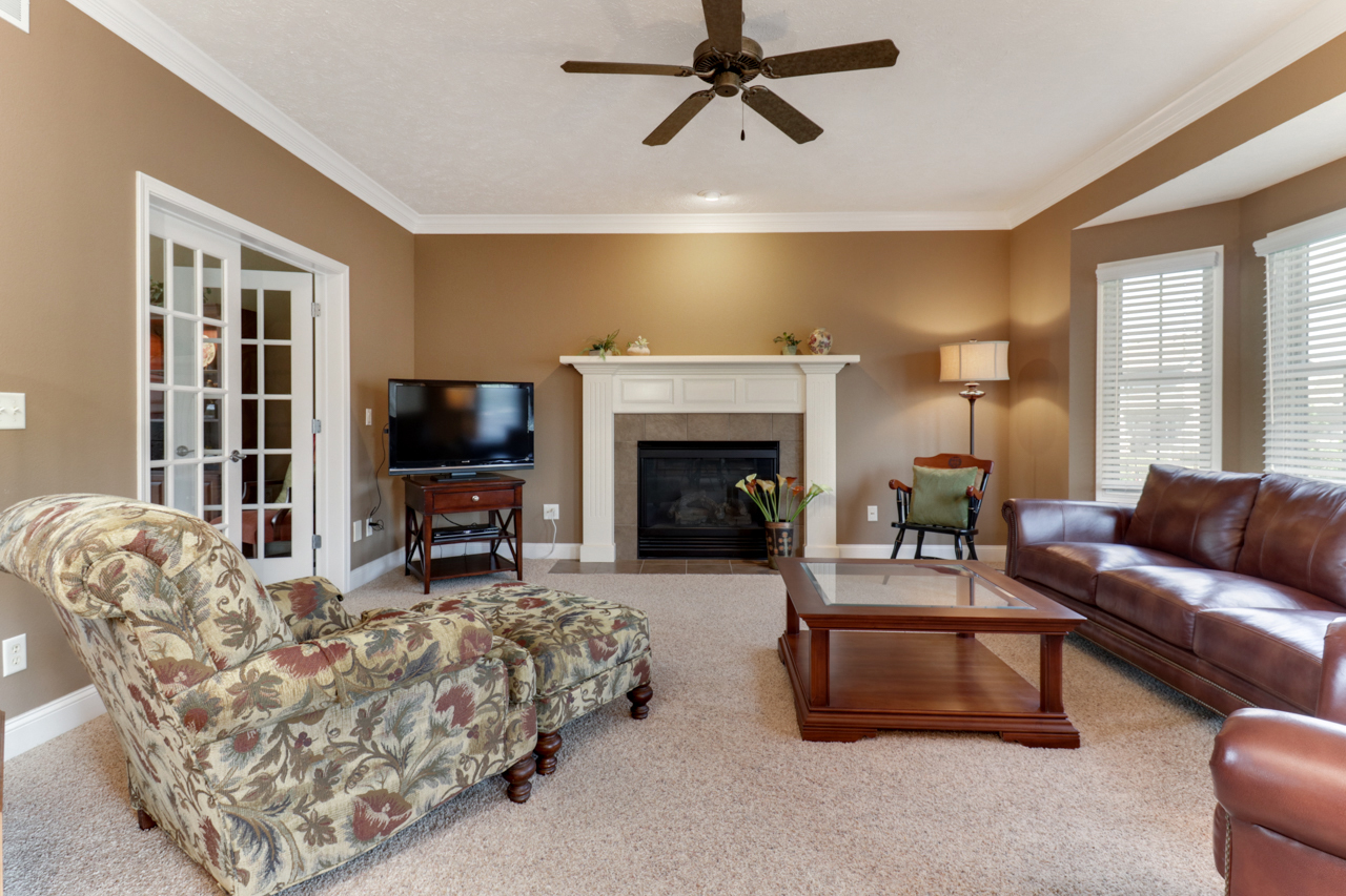 4012 Rockledge Road Bloomington, IL 61705 - Photo 10 of 63 a living room with furniture a flat screen tv and a fireplace