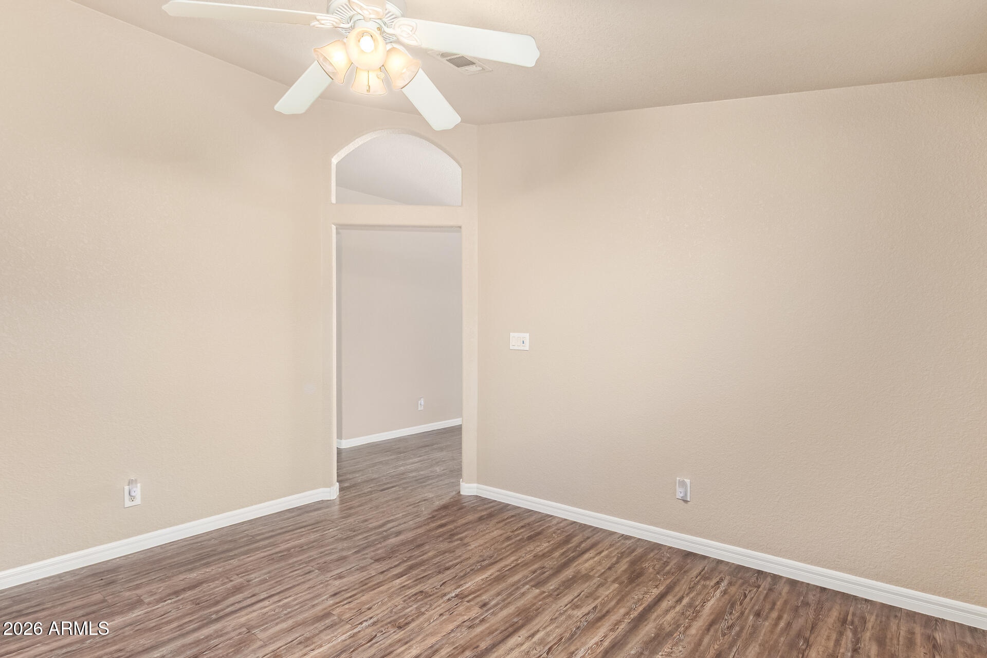 3301 South Goldfield Road, Unit 4028 Apache Junction, AZ 85119 - Photo 7 of 43 an empty room with wooden floor and windows