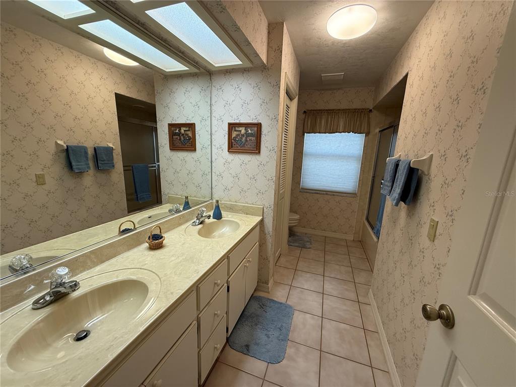 9901 Southwest 67th Terrace Ocala, FL 34476 - Photo 30 of 71 a bathroom with a double vanity sink a mirror and a shower