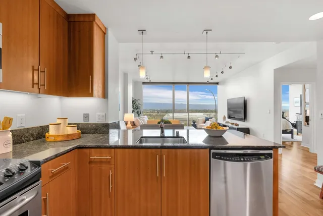 a kitchen with stainless steel appliances wooden cabinets a stove a sink and a refrigerator