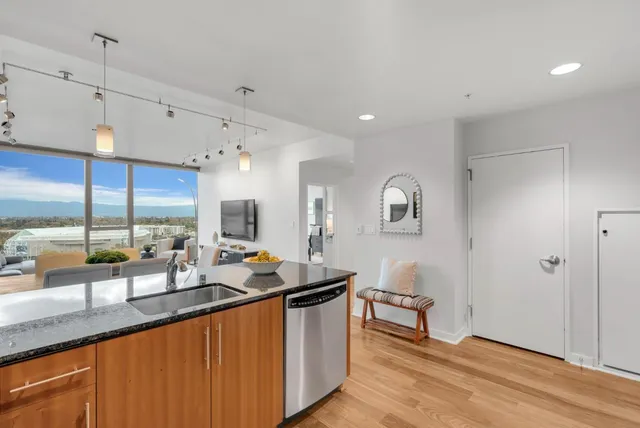 a dining hall with stainless steel appliances granite countertop a sink and a wooden floors