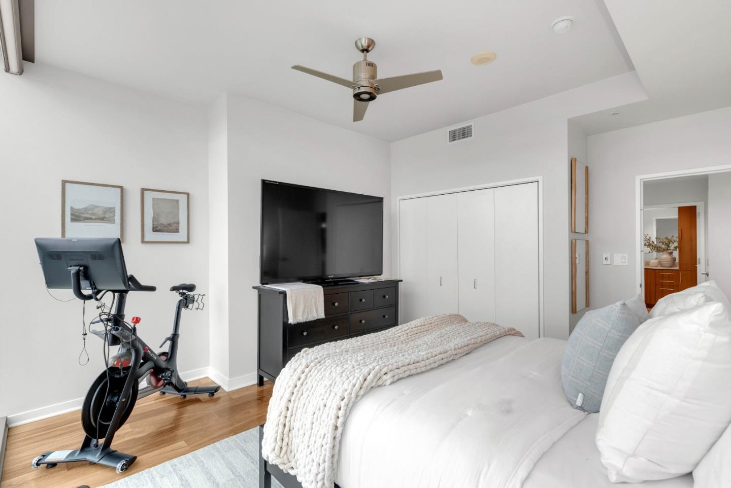 38 North Almaden Boulevard, Unit 1805 San Jose, CA 95110 - Photo 23 of 38 a bedroom with bed a flat tv screen and gym equipment