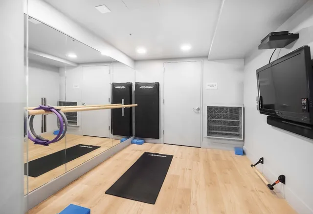 a kitchen with a refrigerator and a television