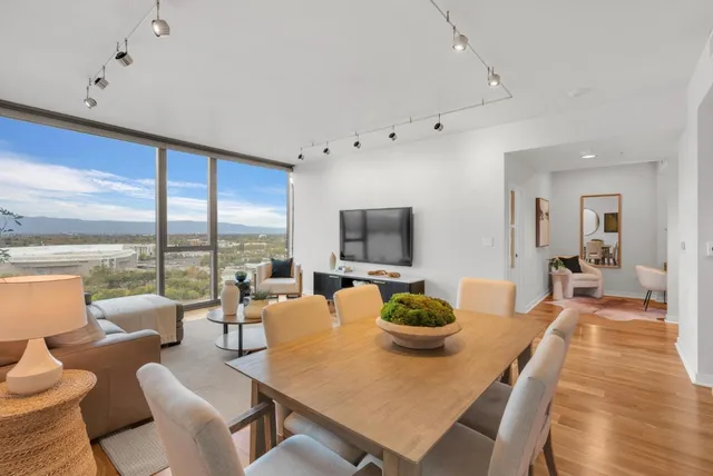 a living room with furniture a large window and a flat screen tv